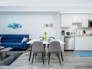 a living room with a blue couch and a table and chairs at Modern 1BR Condo - King bed - Cityscape Views in Kitchener