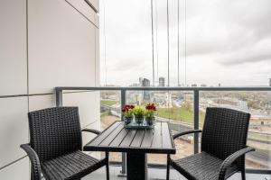 a table with two chairs and a table with flowers on a balcony at 1BR Modern Condo - King Bed and Stunning City View in Kitchener