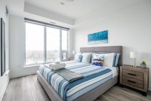 a bedroom with a large bed and a window at 1BR Modern Condo - King Bed and Stunning City View in Kitchener