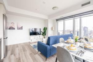 a living room with a blue couch and a table at 1BR Modern Condo - King Bed and Stunning City View in Kitchener