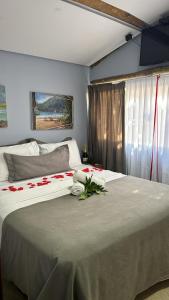 イーリャ・グランデにあるPousada Pé na Areiaのベッドルーム1室(花の咲く大型ベッド1台付)