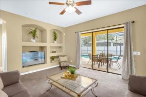 a living room with a ceiling fan and a table at Awesome Bungalow 5BR Home - Swimming Pool and Yard in Davenport