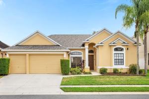 a house with a driveway and palm trees at Awesome Bungalow 5BR Home - Swimming Pool and Yard in Davenport