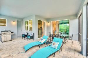 a patio with blue chairs and a table at Stunning Rare Lake Front 7BR Holiday Home - Sleeps 14 - Pool, Hot Tub, & Games! in Orlando