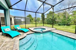 a swimming pool with two blue chairs and a swimming poolvisor at Stunning Rare Lake Front 7BR Holiday Home - Sleeps 14 - Pool, Hot Tub, & Games! in Orlando