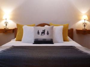 ein Schlafzimmer mit einem Bett mit gelben und weißen Kissen in der Unterkunft Chalet Valloire, 6 pièces, 12 personnes - FR-1-263-360 in Valloire