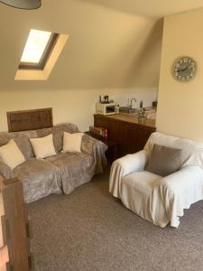 uma sala de estar com um sofá e uma cadeira em Mandarin Cottage- quirky upside down retreat - Norfolk em Mileham