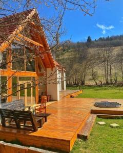 a house with a wooden deck with benches on it at Scrind 11 - Madleine Chalet in Cluj-Napoca