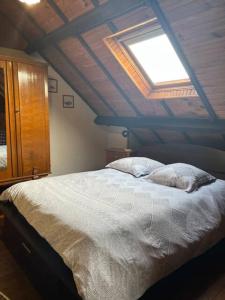 una camera da letto con un grande letto bianco e un lucernario di Appartement rustique, type chalet a Méhoncourt Altre 6 foto