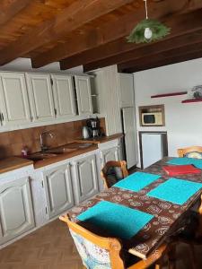 una cucina con tavolo, lavandino, tavolo e sedie di Appartement rustique, type chalet a Méhoncourt