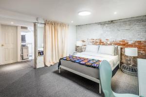 ein Schlafzimmer mit einem Bett und einer Ziegelwand in der Unterkunft Multi-level Townhome Close to Christie Pits Park in Toronto