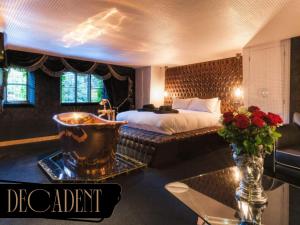 una habitación de hotel con una cama y una mesa con flores en Crazy Bear Stadhampton, en Stadhampton