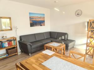 una sala de estar con un sofá y una mesa en Villa Horizont 1, en Baltrum
