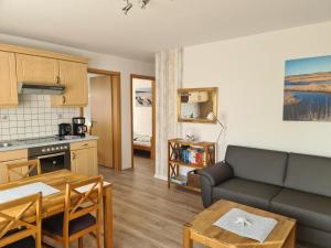 una sala de estar con un sofá y una mesa en Villa Horizont 1, en Baltrum
