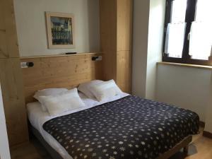 Schlafzimmer mit einem Bett mit einem Kopfteil aus Holz in der Unterkunft Appartement Valloire, 4 pièces, 6 personnes - FR-1-263-363 in Valloire