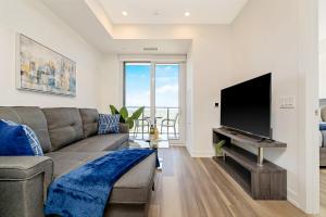 uma sala de estar com um sofá e uma televisão de ecrã plano em Modern 1BR King Bed Condo - Private Balcony em Kitchener