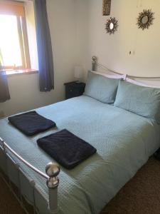 um quarto com uma cama com duas toalhas em Mandarin Cottage- quirky upside down retreat - Norfolk em Mileham