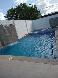 uma piscina com água azul e uma cerca em Vivienda Turística el Refugio em Villavicencio