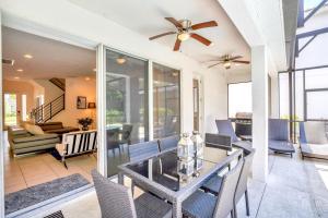 a dining room with a glass table and chairs at Modern 6BR Home - Pool BBQ Hot Tub - Near Disney in Kissimmee