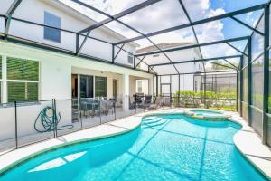 an indoor swimming pool with a glass extension of a house at Modern 6BR Home - Pool BBQ Hot Tub - Near Disney in Kissimmee