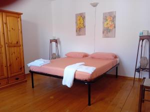 a bedroom with a bed with pink sheets and towels at Su Mulinu 