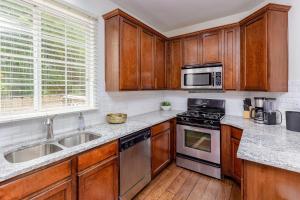 une cuisine avec des placards en bois et des appareils en acier inoxydable dans l'établissement East Austin Family Home - 5 mins from downtown, à Austin