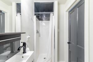 a white bathroom with a shower and a sink at Apartment in the James South Neighborhood in Hamilton