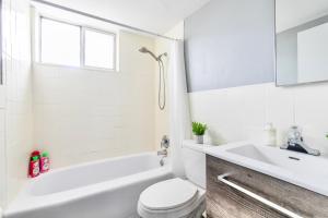 漢密爾頓的住宿－Glenview West Apartment w Patio - Near Downtown，浴室配有白色浴缸、卫生间和水槽。