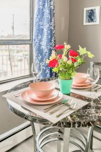 a dining room table with plates and flowers on it at Glenview West Apartment w Patio - Near Downtown in Hamilton