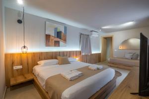 a bedroom with a large bed with two towels on it at Arameras Beach Resort in Ksamil
