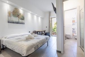 una camera da letto bianca con un letto e un tavolo di MaBi ad Alghero