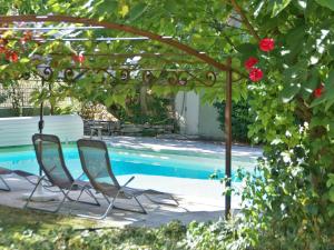 ViensにあるSplendid Villa in Viens with Swimming Poolのスイミングプールの隣のパーゴラの下に椅子2脚