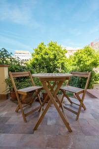 einen Picknicktisch aus Holz und zwei Stühle auf einer Terrasse in der Unterkunft MaBi in Alghero