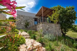 Casa de piedra con techo de madera en Arameras Beach Resort en Ksamil