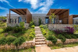 a stone house with a stone path leading up to it at Arameras Beach Resort in Ksamil