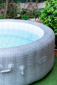 un bain à remous en osier installé sur la pelouse dans l'établissement MONDELLO COTTAGE, à Mondello