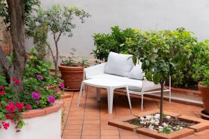 um pátio com um sofá branco e algumas plantas em MONDELLO COTTAGE em Mondello