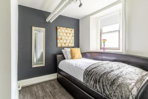 1 dormitorio con cama negra y ventana en Modern Apartment in a Trendy Neighbourhood en Hamilton