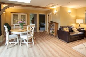 un salon avec une table et un canapé dans l'établissement Folkards Farm Holiday Cottages with hot tubs, à Norwich