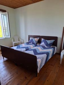 um quarto com uma cama com um edredão azul e branco em Large house at the beach. em Grigoleti