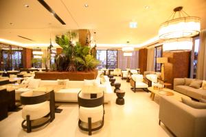 a hotel lobby with couches and tables and chairs at Regina Palm Resort in Orikum