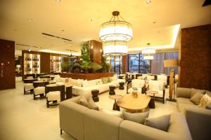 a hotel lobby with couches and tables and chairs at Regina Palm Resort in Orikum