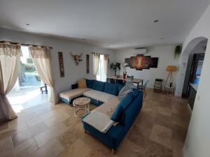 a living room with a blue couch and a table at Villa CALLY, chez MARIUS in Vidauban