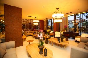 a lobby with couches and tables and flowers in a building at Regina Palm Resort in Orikum