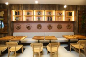 a dining room with wooden tables and chairs and shelves at Regina Palm Resort in Orikum