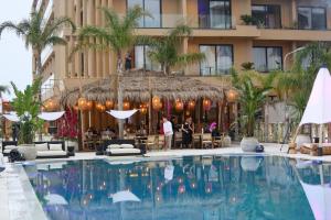 a hotel with a large pool in front of a building at Regina Palm Resort in Orikum