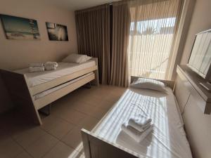 um pequeno quarto com 2 camas e uma janela em Salgados Beach&Golf - Praia dos Salgados em Albufeira