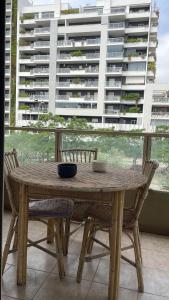 Una mesa de madera con sillas y un gran edificio. en Casa Leone, en Bari