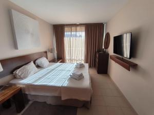 a hotel room with a bed and a television at Salgados Beach&Golf - Praia dos Salgados in Albufeira