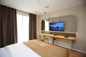 a hotel room with a desk and a television at Regina Palm Resort in Orikum